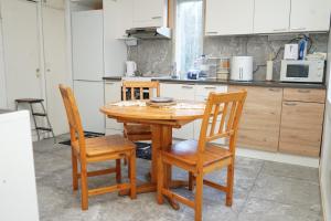 uma cozinha com uma mesa de madeira e 4 cadeiras em Upstairs include bedroom, and living room em Hyvinkää