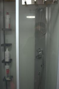 um chuveiro numa casa de banho com uma porta de vidro em Upstairs include bedroom, and living room em Hyvinkää