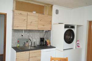uma cozinha com pia e máquina de lavar em Upstairs include bedroom, and living room em Hyvinkää mais 6 fotografias