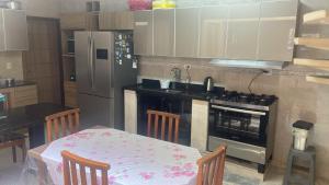 a kitchen with a table and a stove and a refrigerator at Casa Mar in Guaratuba