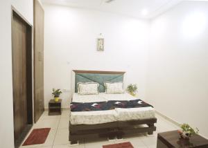 um quarto com uma cama grande em um quarto branco em Hare Krishna Homestay em Agra