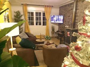 ein Wohnzimmer mit einem Weihnachtsbaum und einer Couch in der Unterkunft Casa Quercus Galicia a 17 minutos de Compostela! in A Estrada