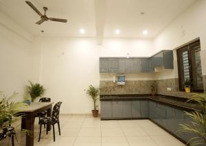 uma cozinha com uma mesa e uma ventoinha de tecto em Hare Krishna Homestay em Agra