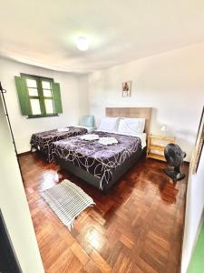 a bedroom with a bed and a wooden floor at Casa Charmosa no Centro Histórico in Ouro Preto