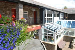 a balcony with flowers and a greenhouse at Dare Valley Accommodation and Campsite in Aberdare