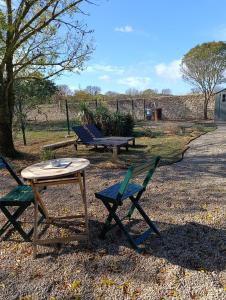 a table and chairs and a picnic table and a bench at Appartement en maison d'hôtes in Badens
