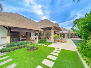 eine Villa mit Garten und Swimmingpool in der Unterkunft Villas Seminyak in Seminyak