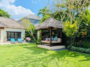 ein Pavillon mit Tisch und Stühlen in einem Hof in der Unterkunft Villas Seminyak in Seminyak