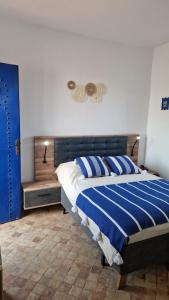 a bedroom with a bed with blue and white stripes at Dar Anouar in Sidi Kaouki