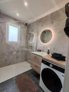 a bathroom with a sink and a glass shower at Gîte De L 'entre 2 Côtes in Vindefontaine