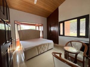 Habitación con sofá, mesa y ventana en RaahgirStays The Lake Nest, en Bhimtal