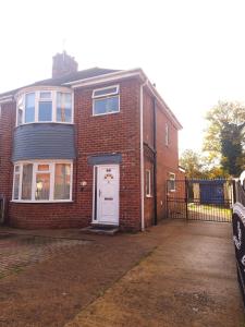 a red brick house with a white door at Bright & cosy 3-bed semi in Wheatley, Doncaster in Arksey
