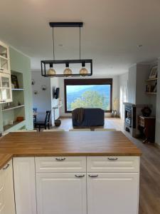 a kitchen with white cabinets and a large window at Villa Pastora in Garganta de los Montes