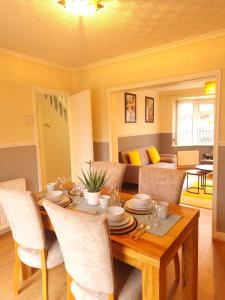 a dining room with a wooden table and chairs at Bright & cosy 3-bed semi in Wheatley, Doncaster in Arksey