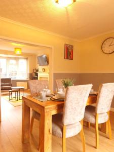 a dining room with a wooden table and chairs at Bright & cosy 3-bed semi in Wheatley, Doncaster in Arksey