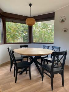 a dining room with a wooden table and chairs at Villa Pastora in Garganta de los Montes