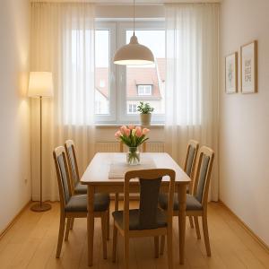 ein Esstisch mit Stühlen und einer Vase mit Blumen in der Unterkunft SUNNYHOME Monteurwohnungen und Apartments nahe Regensburg in Nittendorf