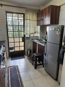 a kitchen with a stainless steel refrigerator and a table at Eden Space Accommodations in Nairobi +8 photos