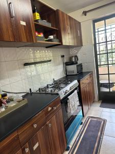 a kitchen with wooden cabinets and a stove top oven at Eden Space Accommodations in Nairobi