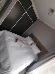 a bed with white sheets and pillows in a room at Khaya guesthouse in Rustenburg