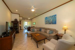 a living room with a couch and a tv at Veranda 8H 3 bdr Garden View in Los Suenos in Herradura