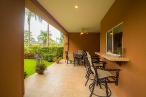 a patio with chairs and a table in a house at Veranda 8H 3 bdr Garden View in Los Suenos in Herradura