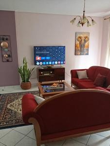 a living room with a couch and a tv at JULIA'S APARTMENT in Igoumenitsa