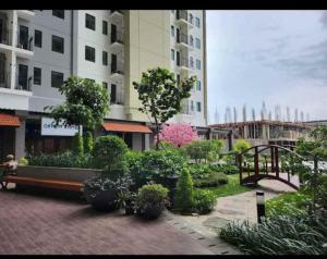 a park with a bench and plants and buildings at Apartemen OSAKA Riverview PIK2 Studio By GPI in Rawalumpang