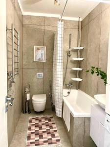 ein Badezimmer mit Badewanne, Toilette und Waschbecken in der Unterkunft Terra с шикарным видом на горы, рядом ТРЦ Mega по розыбакиева in Almaty
