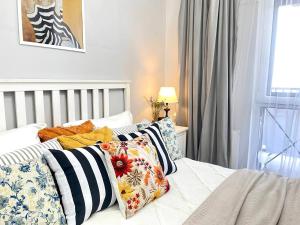 ein Schlafzimmer mit einem Bett mit Kissen darauf in der Unterkunft Terra с шикарным видом на горы, рядом ТРЦ Mega по розыбакиева in Almaty