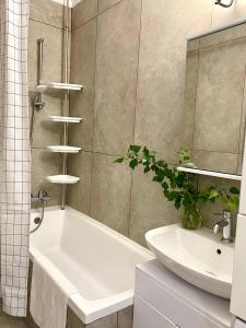 ein Badezimmer mit einer weißen Badewanne und einem Waschbecken in der Unterkunft Terra с шикарным видом на горы, рядом ТРЦ Mega по розыбакиева in Almaty + 34 Fotos