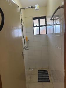 a bathroom with a shower with a glass door at Eden Space Accommodations in Nairobi