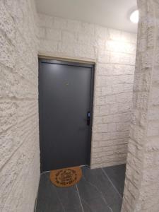 a black door in a room with a stone wall at Appartement spacieux in Lille