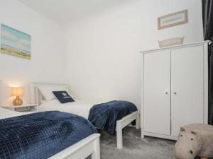a bedroom with two beds and a white cabinet at Wanderers Rest in Lynton