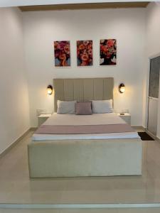 a bedroom with a bed with three pictures on the wall at Dambulla Village Stay in Dambulla