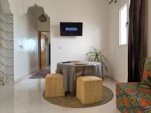 a room with a table and two chairs and a tv at Kaouki beachside apartment - 2 people in Essaouira