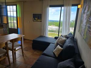 ein Wohnzimmer mit einem blauen Sofa und einem Tisch in der Unterkunft Tornasole,reserva natural,La granja,Cordoba in La Granja