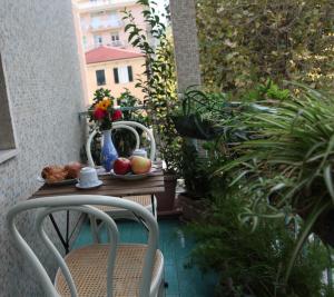 una mesa con un bol de fruta y un jarrón de flores en Amarcorde Home in Corso Buenos Aires con 6 posti letto, en Chiavari