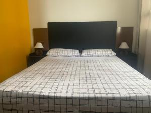 a bedroom with a large bed with two lamps at Kit Dom José in Araxá