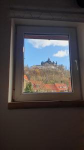 ヴェルニゲローデにあるExklusives Altstadthaus mit Schlossblick zentral in Wernigerodeの丘の上の城を望む窓