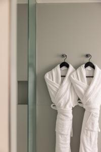 a group of white towels hanging on a rack in a bathroom at 1.75 Paris La Source in Paris