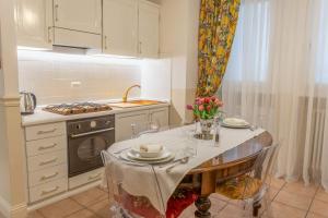 a kitchen with a table with chairs and a stove at City Center Suite - In the elegant heart of Lecco in Lecco