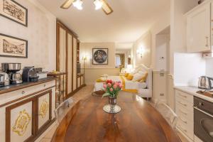 a kitchen and living room with a table with flowers on it at City Center Suite - In the elegant heart of Lecco in Lecco +23 photos
