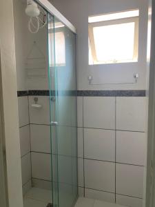 a glass shower in a bathroom with a window at Kit Dom José in Araxá