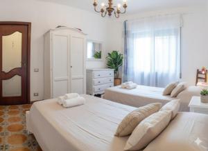 a bedroom with three beds and a chandelier at Da Ernestina in Imperia