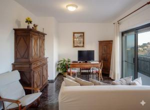 a living room with a couch and a table with a television at Da Ernestina in Imperia