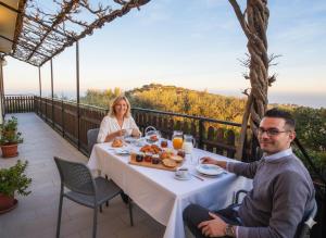 a man and a woman sitting at a table with food at Da Ernestina in Imperia +7 photos
