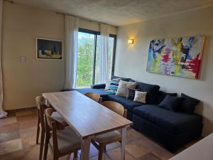 ein Wohnzimmer mit einem blauen Sofa und einem Holztisch in der Unterkunft Tornasole,reserva natural,La granja,Cordoba in La Granja