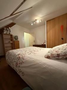a bedroom with a large white bed with flowers on it at Appartement confortable avec piscine à Cour-Cheverny in Cour-Cheverny