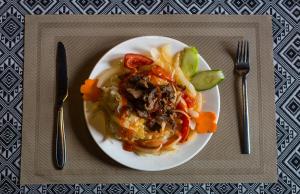 a plate of food with meat and vegetables on a table at Sapa Central House in Sa Pa